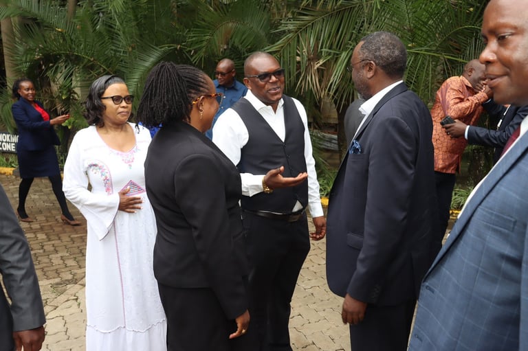 Formal outdoor gathering with formally dressed people conversing in front of tropical plants and palm trees